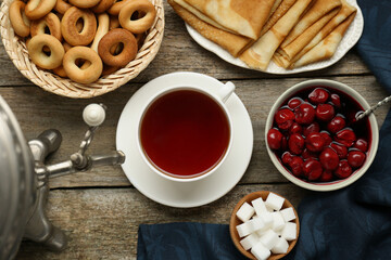 Wall Mural - Metal samovar with cup of tea and treats on wooden table, flat lay