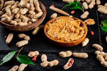 Canvas Print - Peanut butter on a stone board with peanuts in the shell. 