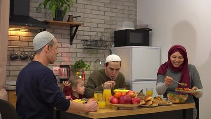 Wall Mural - Muslim family gathering around dining table for Ramadan dinner