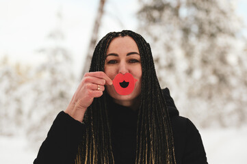 Woman with African braids and red party lips posing for Valentine day in the forest