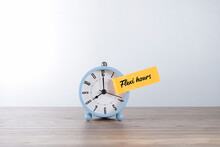 Time Concept.  Flexi Hours Message Written On The Post-it Note And Pasted On The Alarm Clock Face 