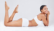 © Wesley JvR/peopleimages.com - Portrait, body and woman in underwear smiling and happy while lying down isolated in a studio white background. Skincare, beauty and slim African female model with natural skin posing for wellness