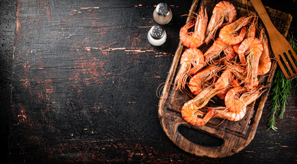 Sticker - Cooked shrimp on a cutting board with spices and rosemary.