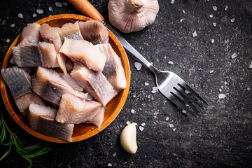 Sticker - Salted herring on a wooden plate with garlic and rosemary. 