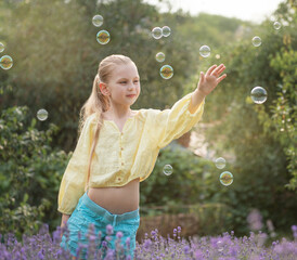 beautiful little girl in a field with lavender.