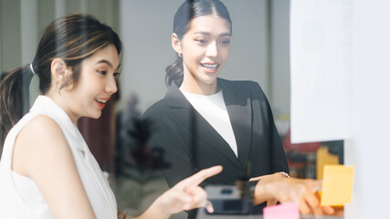 Wall Mural - Southeast asian business women wearing suit with smile face talking together in office