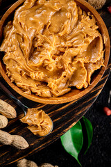 Canvas Print - Peanut butter on a wooden tray with leaves. 