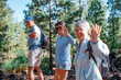 © luciano - Cheerful group of elderly people hiking in a mountain park enjoying healthy activity and lifestyle. Man and women looking smiling at camera