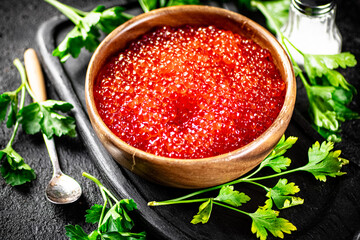 Poster - Red caviar in a plate on a cutting board with parsley. 