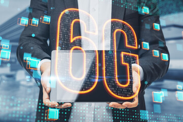 Aufkleber - hand holding tablet with glowing 6g hologram on blurry office interior background. 6G network concept, high speed mobile internet, new generation networks. Mixed media. Double exposure.