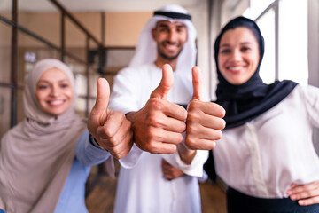 Wall Mural - Middle-eastern group of corporate businesspeople working in a business office - Arab businessman with kandora and businesswomen with abaya meeting in the office in Dubai, UAE