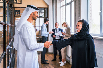 Multiracial group of corporate businesspeople working in a business office - Multiethnic businessmen and businesswomen meeting in the office in Dubai, UAE