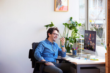 laughing man chatting via smartphone in office