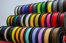 Many Multi-colored Spools Of Thread Of Filament For Printing 3d Printer. Material Coils For Printing 3D Printer. Spools Of 3D Printing Motley Different Colors Filament. ABS Wire Plastic For 3d Printer