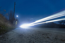 Light Traces Of Passing Cars At Sunset. Long Time Exposure, Motion Blur Effect.