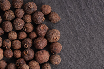 Poster - a bunch of natural allspice in peas on a gray stone texture surface