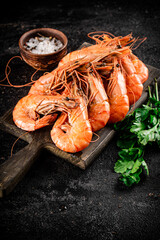 Poster - Boiled shrimp on a cutting board with parsley and spices. 