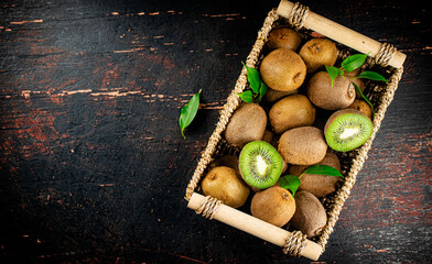 Wall Mural - Fresh kiwi with leaves in a basket. 