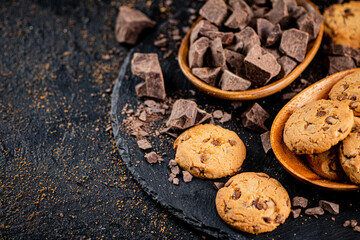 Wall Mural - Cookies with pieces of milk chocolate on a stone board. 