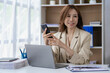 © ArLawKa - Asian businesswoman working with financial documents, discussing with clients with smartphone and laptop computer on table, analysis plan, financial report. Business plan. Investment finance concept.