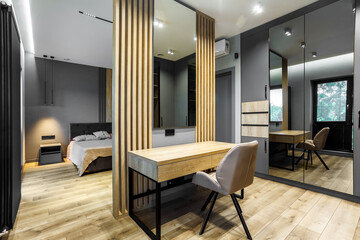 Modern luxury bedroom in loft style with dark and grey style. Dark headboard and wooden floor with wall panel