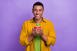 © deagreez - Photo of optimistic good mood toothy beaming guy dressed yellow shirt hands holding coffee cup isolated on violet color background