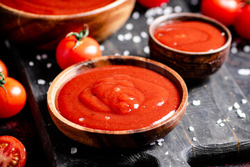 Canvas Print - Tomato sauce on a wooden cutting board with pieces of salt. 