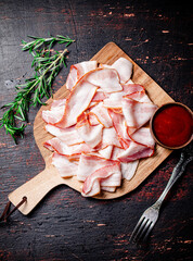 Sticker - Pieces of bacon on a cutting board with tomato sauce.