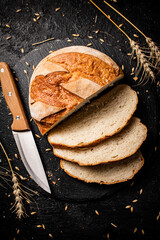 Poster - Sliced on a stone board wheat bread with grains. 