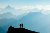 Fototapeta Sawanna - Silhouette Couple of man and woman reaching mountain top enjoying freedom and looking towards blue mountain silhouettes and sunrise. Alps, Allgaeu, Bavaria, Germany.