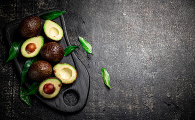 Wall Mural - Fresh avocado with foliage on a cutting board.