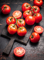 Wall Mural - Fresh tomatoes on a wooden cutting board. 