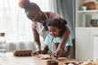 © Seventyfour - Candid loving mother and daughter baking together at home