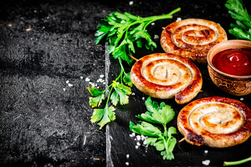 Poster - Grilled sausages on a stone board with tomato sauce and parsley. 