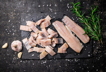 Poster - Pieces of salted herring on a stone board with garlic and rosemary. 