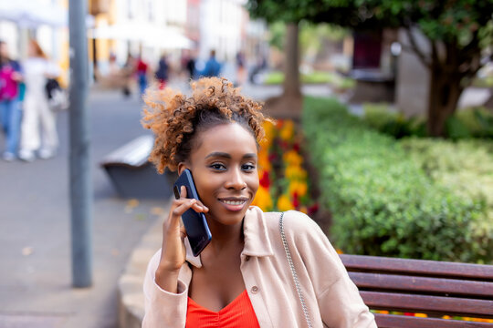 Happy woman walking using a cellphone in the street
