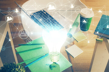 Poster - Computer on desktop in office with bulb icon hologram. Double exposure. Concept of idea.