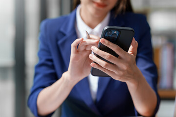 Attractive beautiful Asian woman is using a smartphone to send a message work or play various social and entertainment applications.