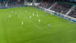 Aerial Shot: Soccer Football Championship: Black Forward From Blue Team Attacks, White Team Defends The Goals, Ready to Counterattack. Crowd of Fans Cheer. Sports TV Broadcast Concept. High Angle.