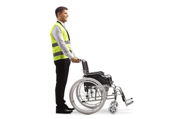 Canvas Print - Full length profile shot of a guard standing behind a wheelchair