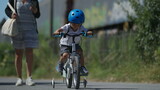 Fototapeta Do pokoju - Small boy riding bicycle outside child rides bike wearing helmet