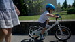 Child riding bicycle outside in urban street little boy rides bike on sidewalk
