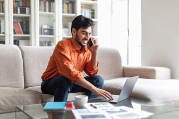 Wall Mural - Wealthy arab businessman working from home, using laptop