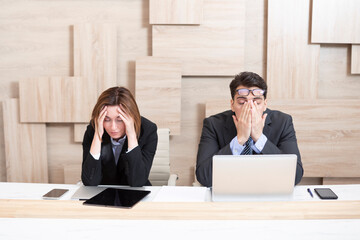 stressed male and female business persons sitting at desk, hard thinking about problem. businessman 