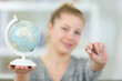 © auremar - smiling woman holding a globe and a simcard