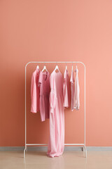 Wall Mural - Rack with female clothes near pink wall