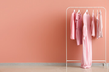 Wall Mural - Rack with female clothes near pink wall