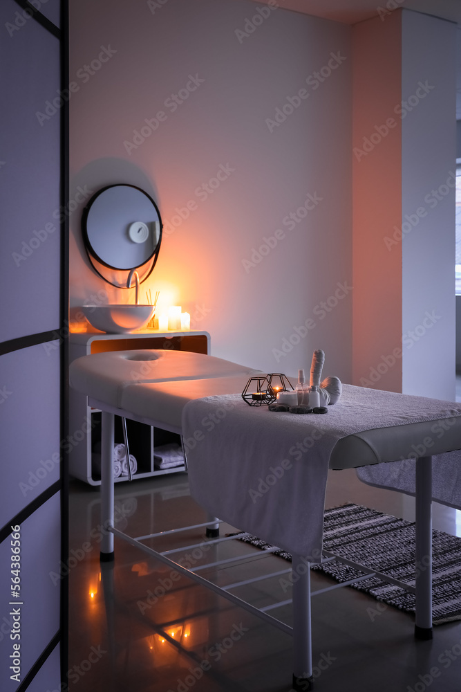 Interior of dark spa salon with couch, sink and mirror