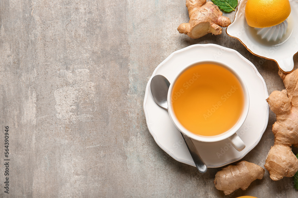 Cup of tea, lemon, spoon and ginger on grunge background