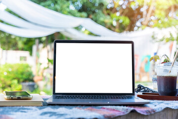 Wall Mural - Mockup of laptop computer with empty screen with coffee cup and smartphone on table beside the window of the coffee shop background,White screen